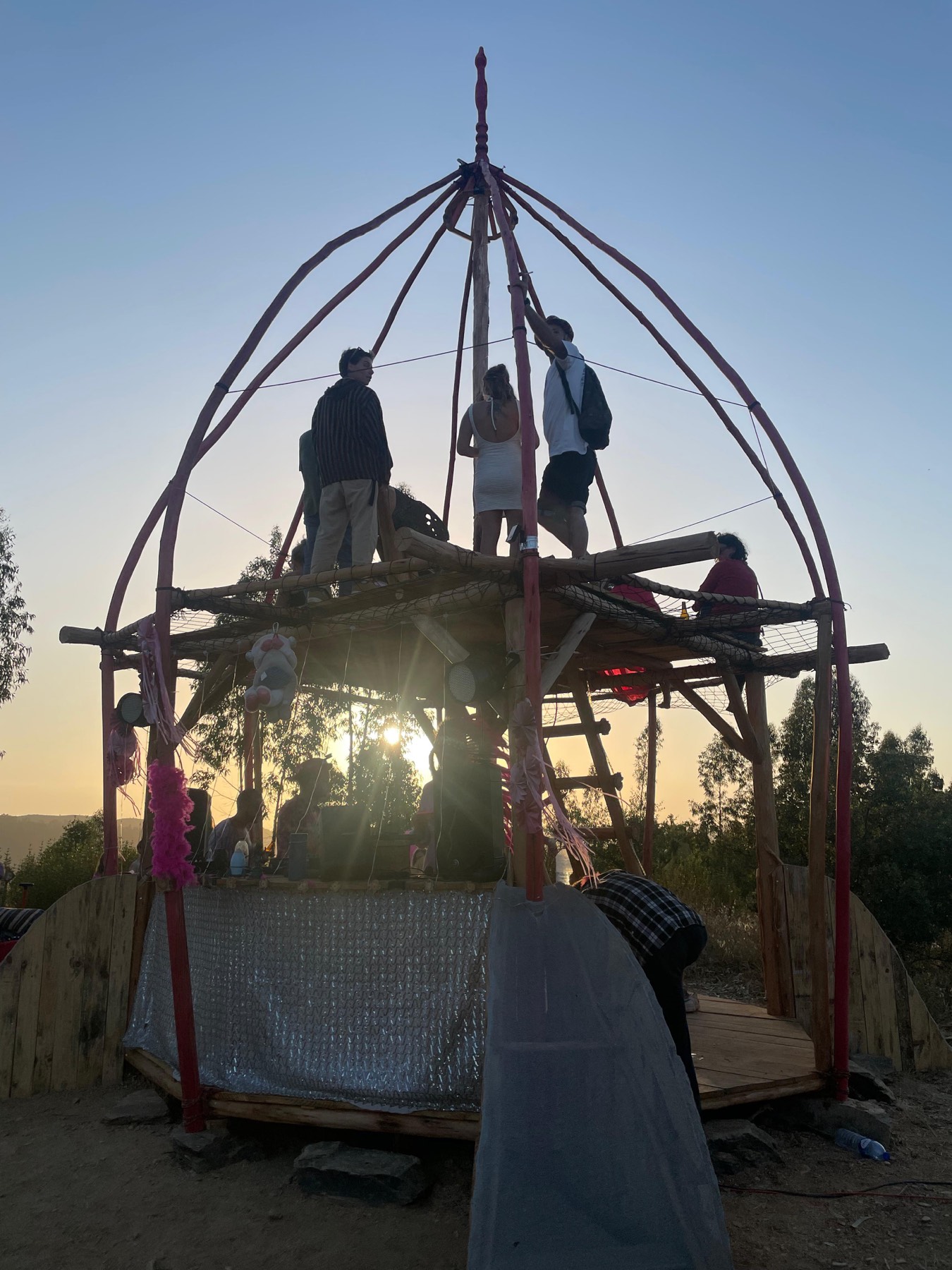 A timber and scaffold structure being built at sunset