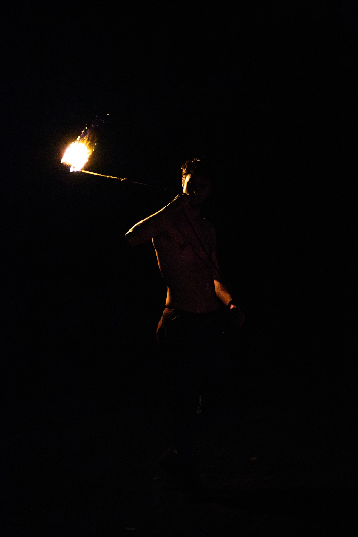 A torch and one figure in the dark.